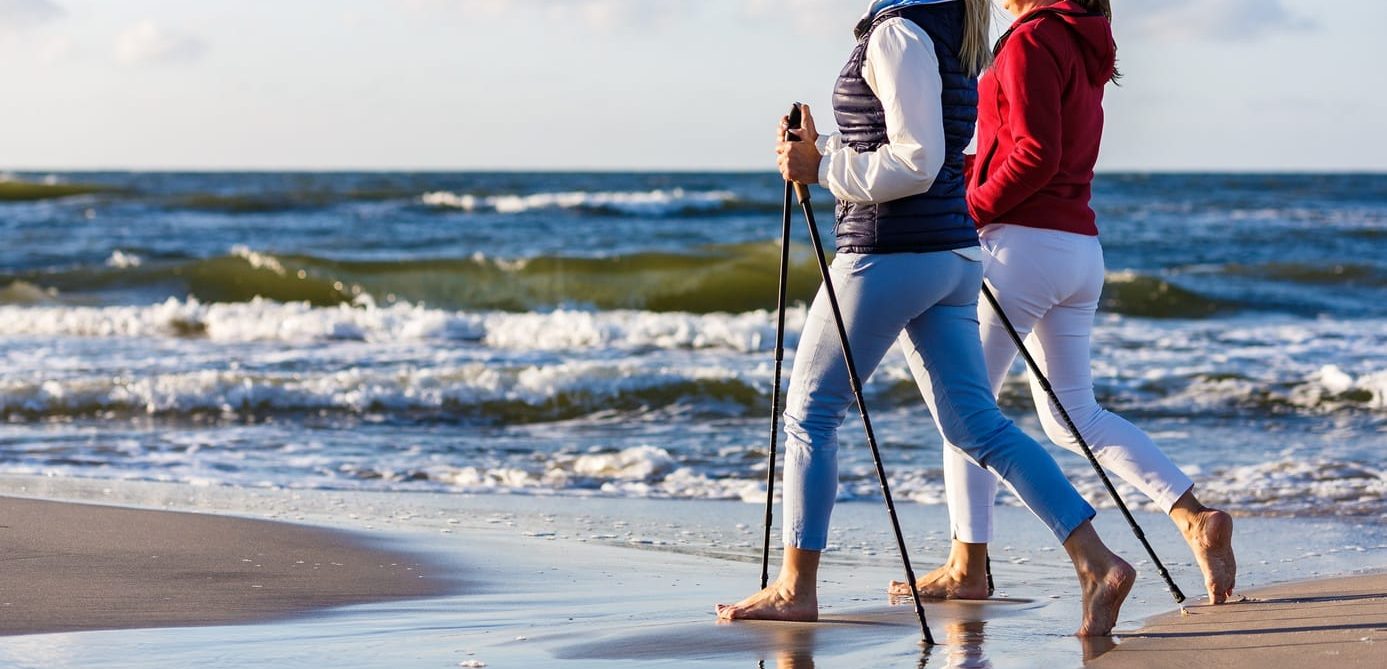 Nordic walking – two women working out on beach